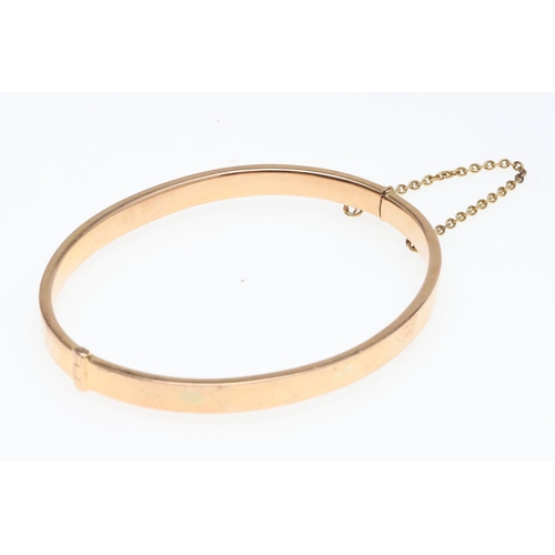 802 - A 15CT GOLD HALF HINGED BANGLE. of oval shape and plain form, internal measurements 5 x 6.2cm., 8.3 ... 