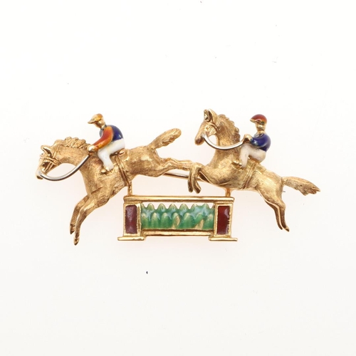 850 - AN 18CT GOLD AND ENAMEL HORSE AND JOCKEY BROOCH. depicting two jockeys jumping over a fence, with re... 