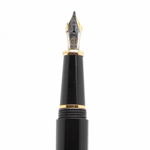 859 - A BLACK FOUNTAIN PEN BY CARTIER. with gold plated decoration, 18ct gold nip, in a red leather box by... 