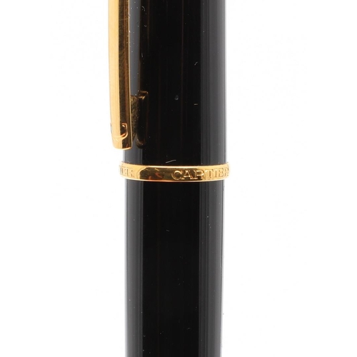 859 - A BLACK FOUNTAIN PEN BY CARTIER. with gold plated decoration, 18ct gold nip, in a red leather box by... 