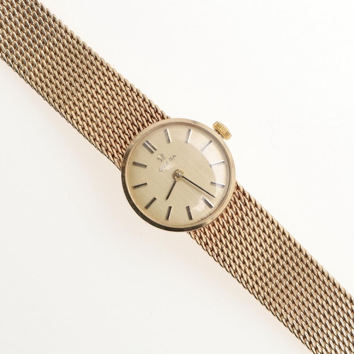 885 - A LADY'S 9CT GOLD WRISTWATCH BY OMEGA. the signed circular dial with baton numerals, on an  integrat... 