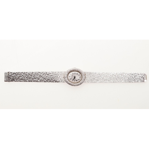 887 - A LADY'S 18CT WHITE GOLD WRISTWATCH BY BUECHE-GIROD. the signed oval-shaped textured white gold dial... 