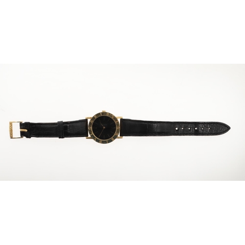 890 - AN 18CT GOLD WRISTWATCH BY BULGARI. the circular black dial with baton numerals and Arabic numerals ... 