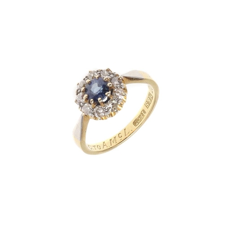 907 - A SAPPHIRE AND DIAMOND SET CLUSTER RING. the circular-cut sapphire is set within a surround of circu... 