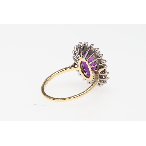 908 - AN AMETHYST AND DIAMOND CLUSTER RING. the oval-shaped amethyst is set within a surround of circular-... 