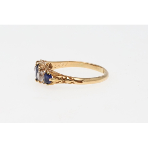 911 - A SAPPHIRE AND DIAMOND FIVE STONE RING. the three graduated oval-shaped sapphires are set with two c... 