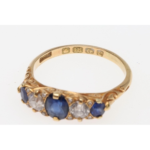 911 - A SAPPHIRE AND DIAMOND FIVE STONE RING. the three graduated oval-shaped sapphires are set with two c... 