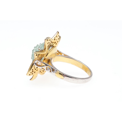 924 - AN AQUAMARINE AND DIAMOND RING. centred with a foliate carved circular-cut aquamarine weighing 3.90 ... 