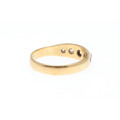 926 - AN 18CT GOLD AND DIAMOND GYPSY RING. mounted with graduated circular old-cut diamonds, 4.4 grams. Si... 