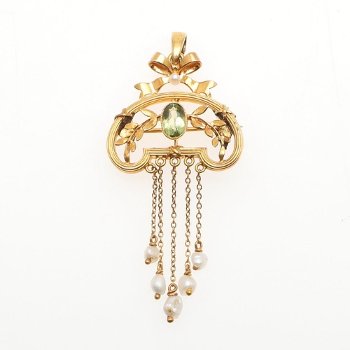 943 - AN EDWARDIAN PERIDOT AND PEARL BROOCH PENDANT. the gold foliate and scrolling mount is centred  with... 