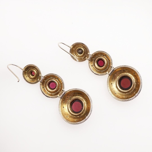 954 - A PAIR OF GARNET DROP EARRINGS. each earring formed as three graduated silver gilt circles with embo... 