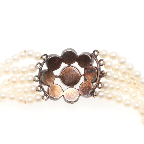 955 - A FIVE ROW CULTURED PEARL AND PASTE SET CHOKER. the cultured pearls measure approximately 3.5mm and ... 