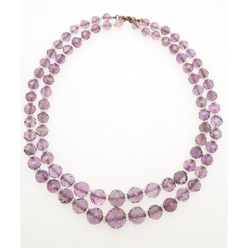 970 - AN AMETHYST NECKLACE. mounted with graduated oval-shaped amethyst drops in gilt metal, 35.5cm long, ... 