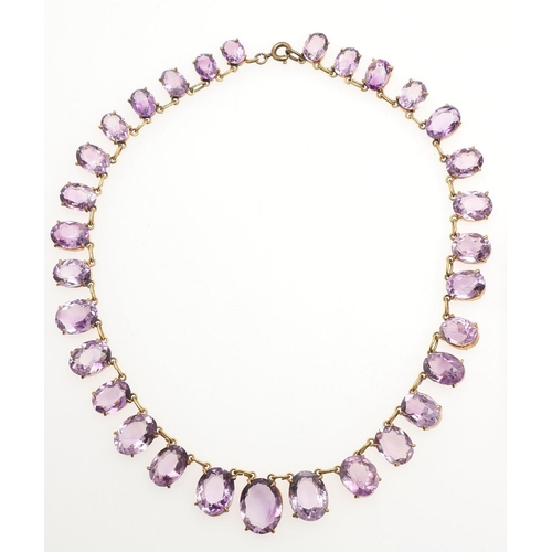 970 - AN AMETHYST NECKLACE. mounted with graduated oval-shaped amethyst drops in gilt metal, 35.5cm long, ... 