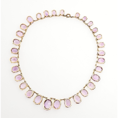 970 - AN AMETHYST NECKLACE. mounted with graduated oval-shaped amethyst drops in gilt metal, 35.5cm long, ... 