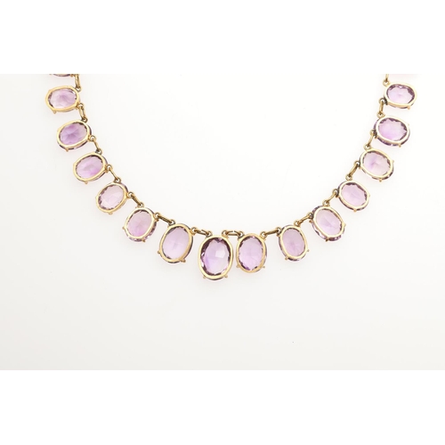 970 - AN AMETHYST NECKLACE. mounted with graduated oval-shaped amethyst drops in gilt metal, 35.5cm long, ... 