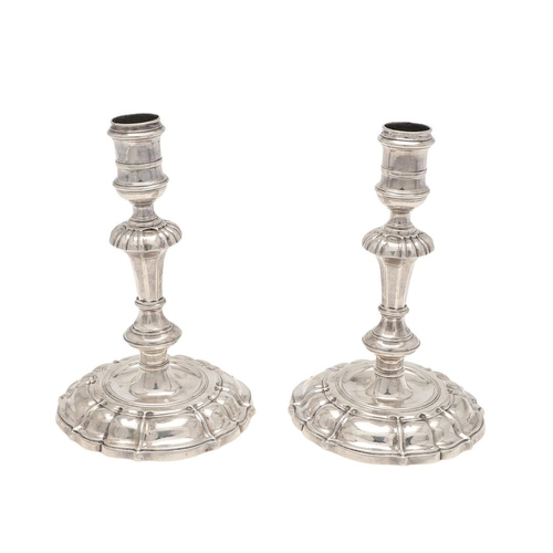 147 - A PAIR OF GEORGE II CAST SILVER CANDLESTICKS. on shaped circular bases, with knopped stems and spool... 