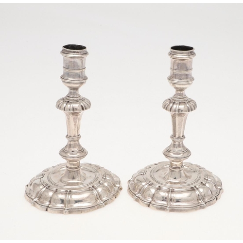 147 - A PAIR OF GEORGE II CAST SILVER CANDLESTICKS. on shaped circular bases, with knopped stems and spool... 