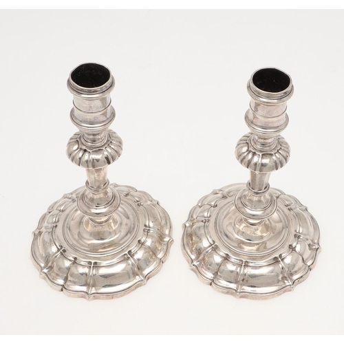 147 - A PAIR OF GEORGE II CAST SILVER CANDLESTICKS. on shaped circular bases, with knopped stems and spool... 