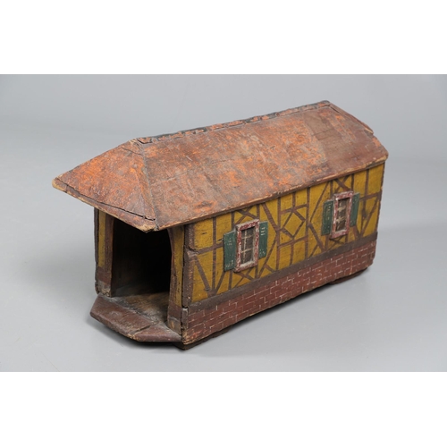 475 - A FOLK ART POLYCHROME PAINTED DOG KENNEL. circa 1900, in the form of a brick and cob barn with appli... 