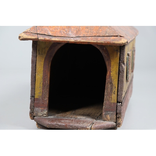 475 - A FOLK ART POLYCHROME PAINTED DOG KENNEL. circa 1900, in the form of a brick and cob barn with appli... 