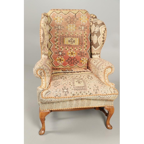 479 - A GEORGE II STYLE WALNUT WING ARMCHAIR. upholstered in a kelim fabric with braiding, the cabriole le... 