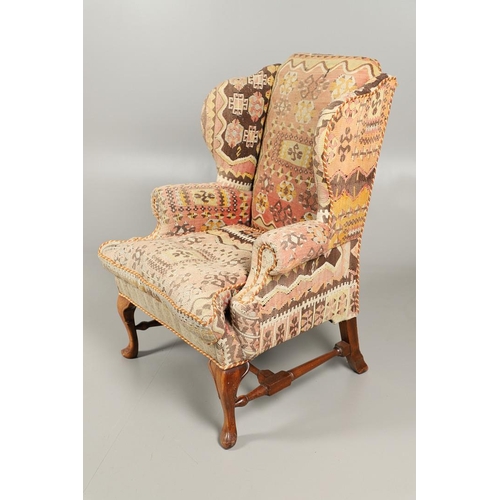 479 - A GEORGE II STYLE WALNUT WING ARMCHAIR. upholstered in a kelim fabric with braiding, the cabriole le... 