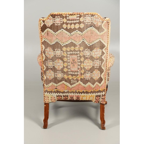 479 - A GEORGE II STYLE WALNUT WING ARMCHAIR. upholstered in a kelim fabric with braiding, the cabriole le... 