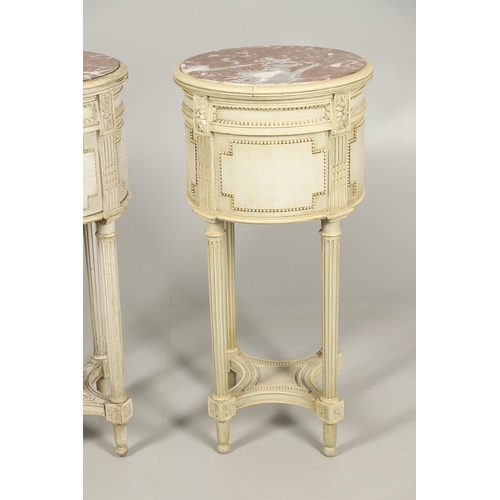 495 - A PAIR OF FRENCH MARBLE TOP PAINTED POT CUPBOARDS. of cylindrical form with moulded Classical motif ... 