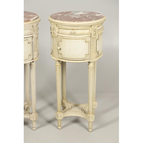 495 - A PAIR OF FRENCH MARBLE TOP PAINTED POT CUPBOARDS. of cylindrical form with moulded Classical motif ... 