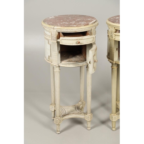 495 - A PAIR OF FRENCH MARBLE TOP PAINTED POT CUPBOARDS. of cylindrical form with moulded Classical motif ... 