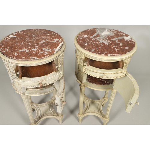 495 - A PAIR OF FRENCH MARBLE TOP PAINTED POT CUPBOARDS. of cylindrical form with moulded Classical motif ... 