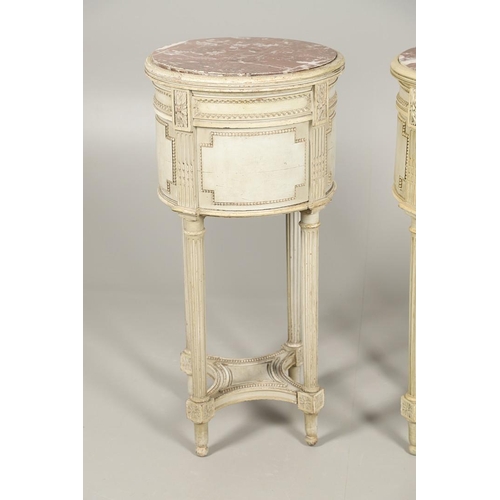 495 - A PAIR OF FRENCH MARBLE TOP PAINTED POT CUPBOARDS. of cylindrical form with moulded Classical motif ... 