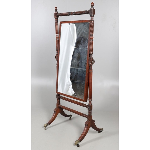 503 - A REGENCY MAHOGANY CHEVAL MIRROR. the frame with turned spiral and flower head detail and acorn fini... 