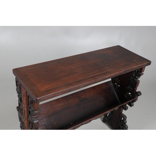 506 - AN EARLY 20TH CENTURY CHINESE HARDWOOD BOOK TROUGH. the ends carved with dragon's heads and low reli... 