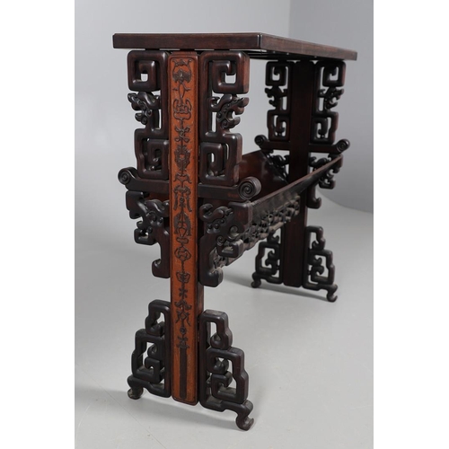 506 - AN EARLY 20TH CENTURY CHINESE HARDWOOD BOOK TROUGH. the ends carved with dragon's heads and low reli... 