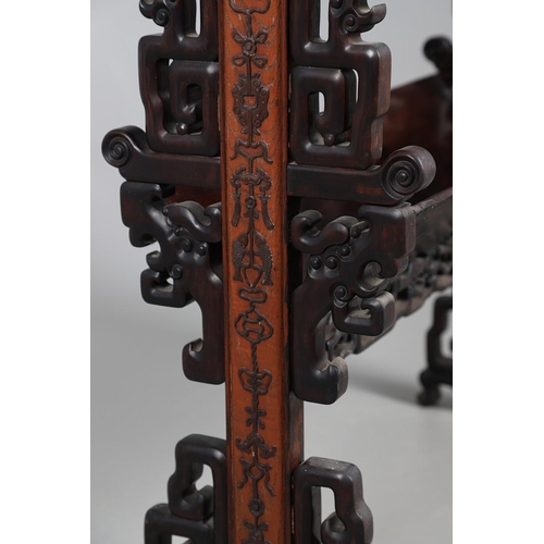 506 - AN EARLY 20TH CENTURY CHINESE HARDWOOD BOOK TROUGH. the ends carved with dragon's heads and low reli... 