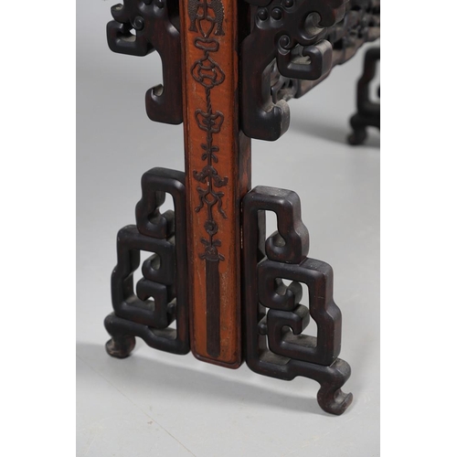 506 - AN EARLY 20TH CENTURY CHINESE HARDWOOD BOOK TROUGH. the ends carved with dragon's heads and low reli... 