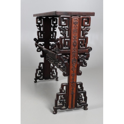 506 - AN EARLY 20TH CENTURY CHINESE HARDWOOD BOOK TROUGH. the ends carved with dragon's heads and low reli... 