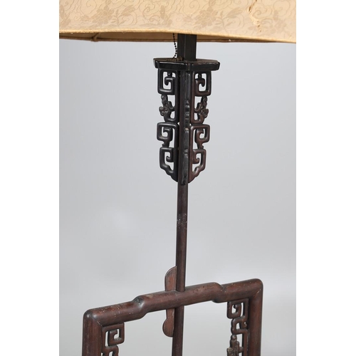 507 - AN EARLY 20TH CENTURY CHINESE HARDWOOD STANDARD LAMP. the ends carved with foliate and cloud detail,... 