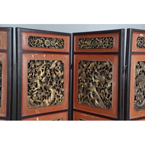 509 - A CHINESE CARVED AND LACQUERED SIX FOLD SCREEN. early 20th century, each red and black lacquered pan... 