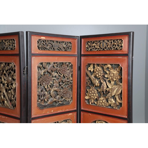 509 - A CHINESE CARVED AND LACQUERED SIX FOLD SCREEN. early 20th century, each red and black lacquered pan... 