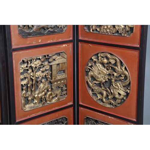 509 - A CHINESE CARVED AND LACQUERED SIX FOLD SCREEN. early 20th century, each red and black lacquered pan... 