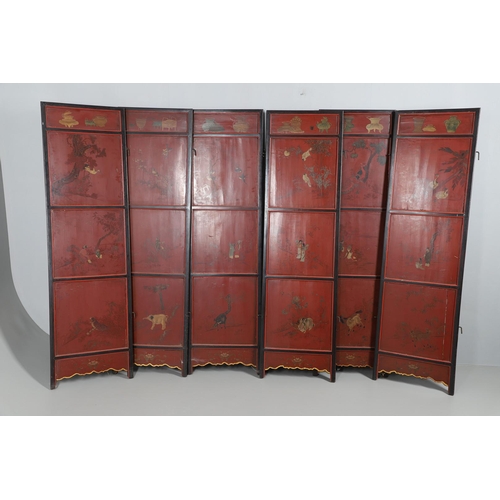 509 - A CHINESE CARVED AND LACQUERED SIX FOLD SCREEN. early 20th century, each red and black lacquered pan... 