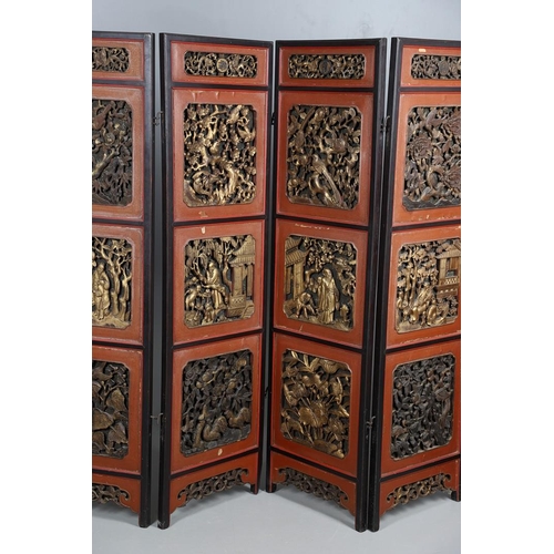 509 - A CHINESE CARVED AND LACQUERED SIX FOLD SCREEN. early 20th century, each red and black lacquered pan... 