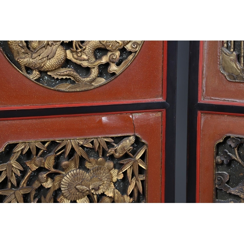 509 - A CHINESE CARVED AND LACQUERED SIX FOLD SCREEN. early 20th century, each red and black lacquered pan... 