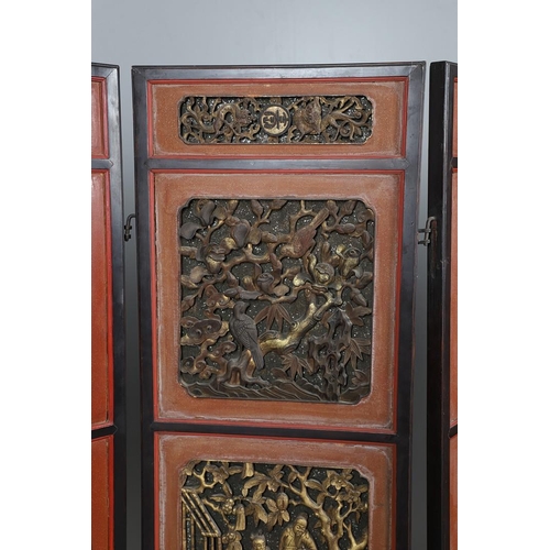 509 - A CHINESE CARVED AND LACQUERED SIX FOLD SCREEN. early 20th century, each red and black lacquered pan... 