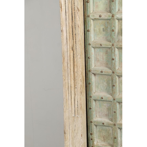 512 - A PAIR OF INDIAN PAINTED HARDWOOD DOORS. 20th century, each door panelled and metal studded with iro... 