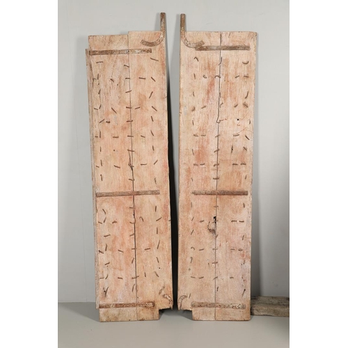 512 - A PAIR OF INDIAN PAINTED HARDWOOD DOORS. 20th century, each door panelled and metal studded with iro... 