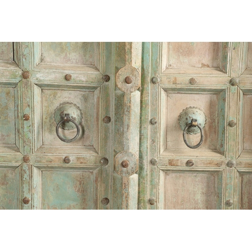 512 - A PAIR OF INDIAN PAINTED HARDWOOD DOORS. 20th century, each door panelled and metal studded with iro... 